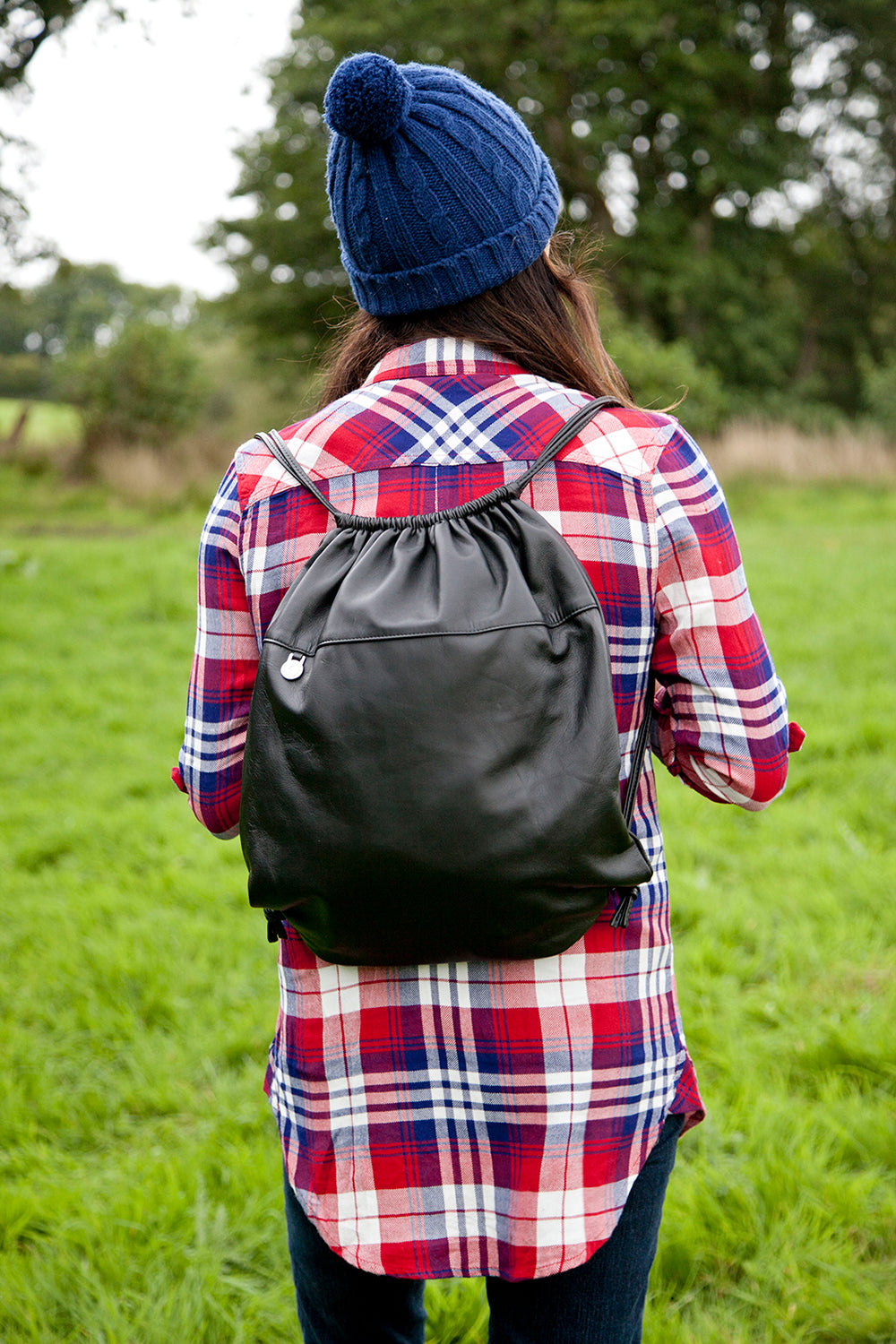 Black Pittards leather drawstring bag worn on a countryside walk